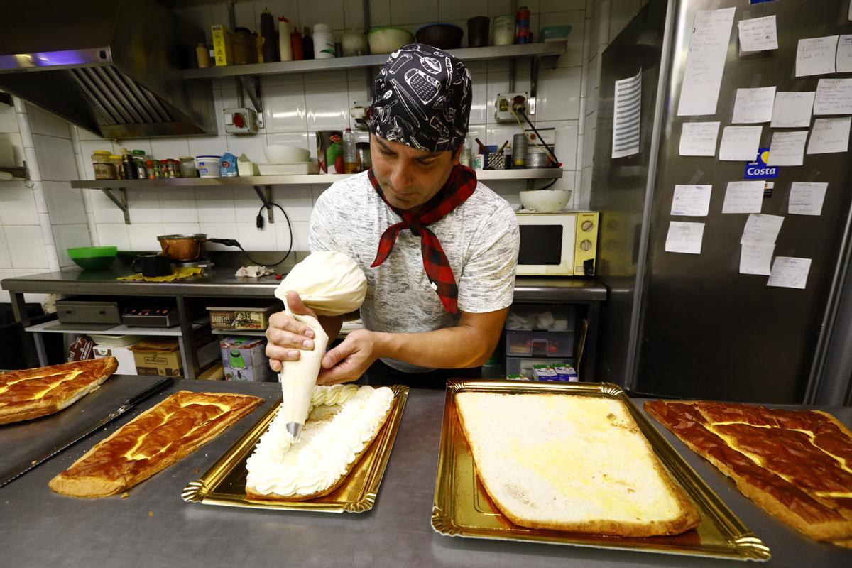 El pastelero Pedro Fernández rellena con nata uno de los dulces