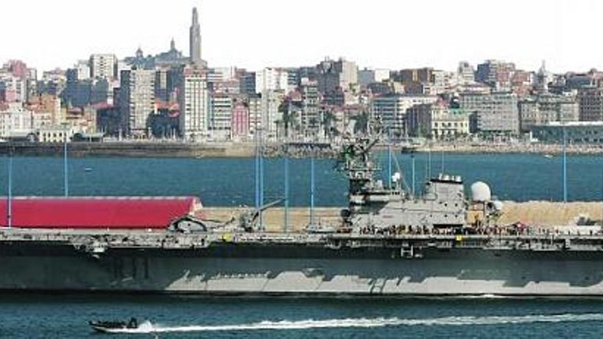 Una panorámica del portaaviones «Príncipe de Asturias (R-11)», atracado, ayer, de estribor en los muelles de La Osa del puerto exterior de El Musel, con Gijón al fondo y la torre de la Laboral.