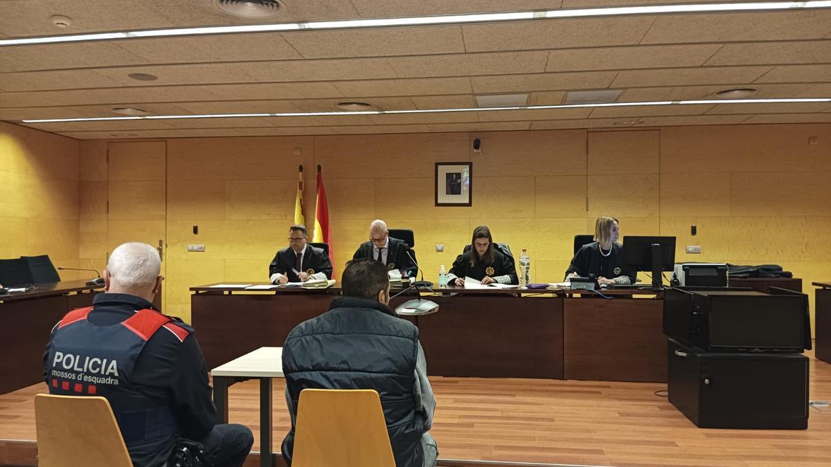 L'acusat, escortat pels Mossos, durant el judici a l'Audiència de Girona.