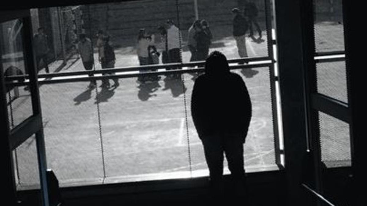 Un alumno observa a sus compañeros en el patio de un instituto de Barcelona.