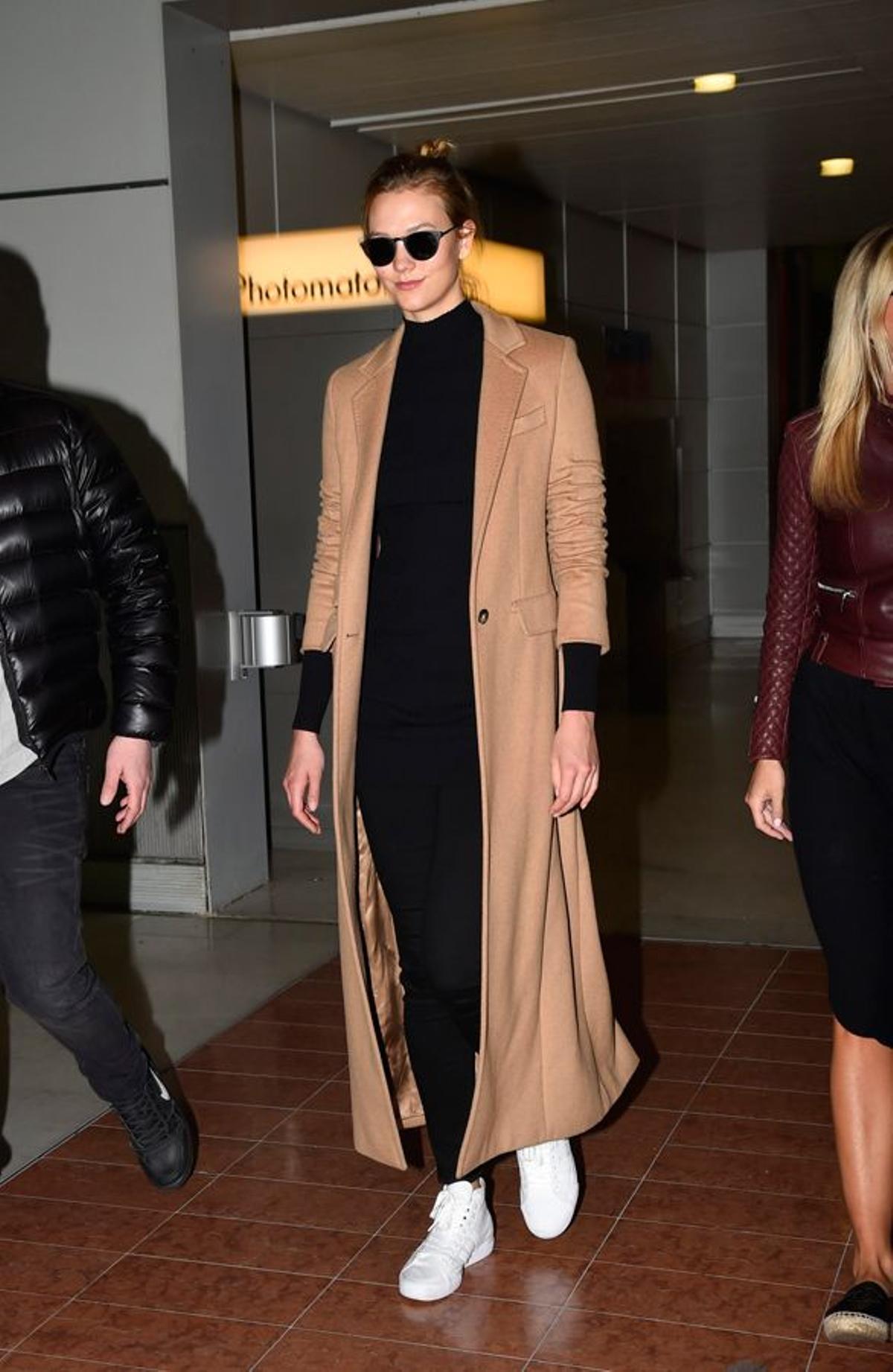 Karlie Kloss con abrigo camel y zapatillas blancas