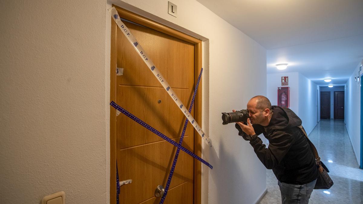 Un cámara fotografía el precinto policial en la entrada a la vivienda de El Puerto de Santa Maria.