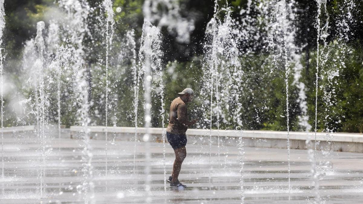 Una persona se baña en los chorros ornamentales del Parc Central