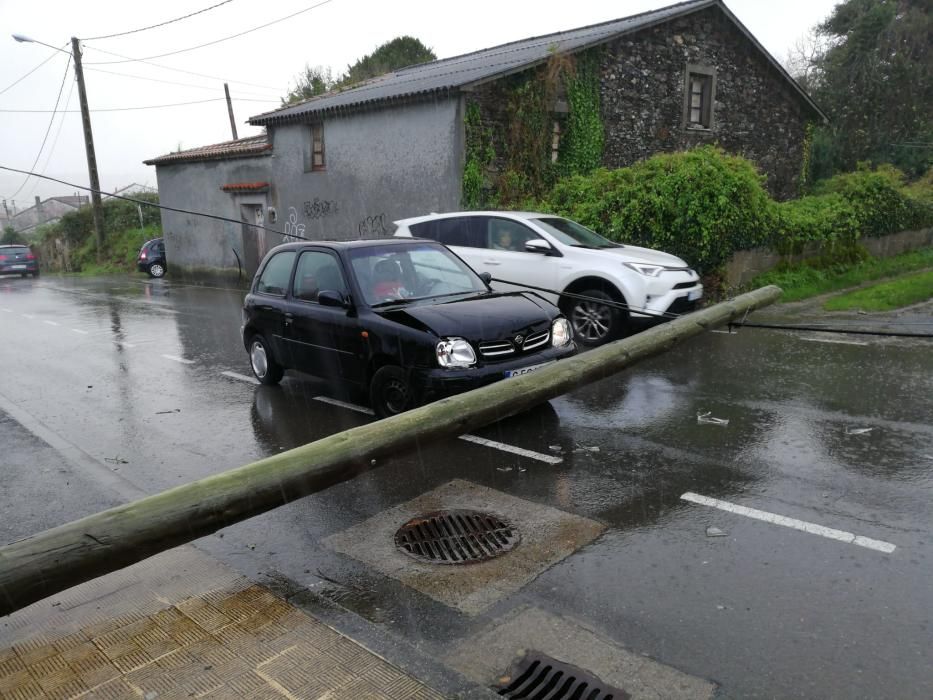 Poste derribado sobre un vehículo, en Oleiros.