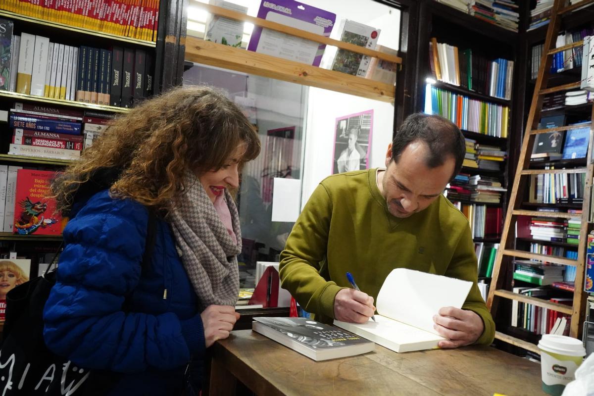 Ángel Martín le firma a una lectora su libro 'Por si las voces vuelven'.