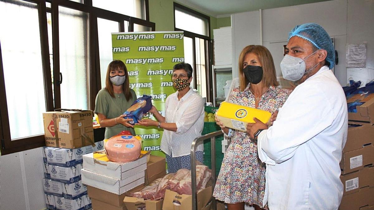 Ángela Trelles, de Supermercados Masymas (primera por la izquierda), y Luisa López, jefa de publicidad de  LA NUEVA ESPAÑA, durante el acto de entrega del resultado de la campaña solidaria del Martes de Campo. | LNE