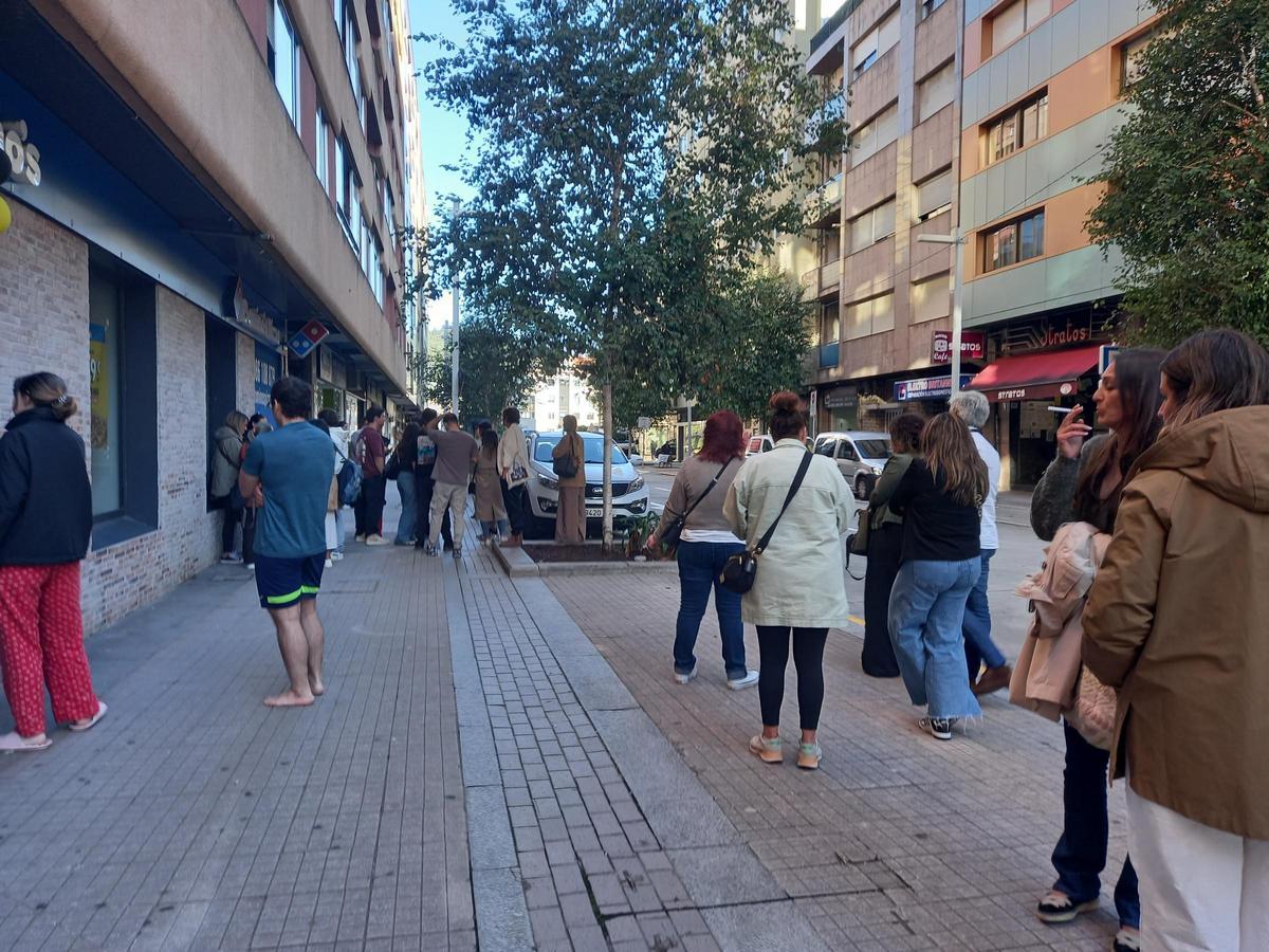 Trabajadores en el exterior del edificio tras ser evacuados.
