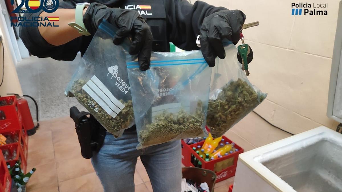 Ein Beamter der Nationalpolizei hält Gefriertüten mit Marihuana in die Kameras.