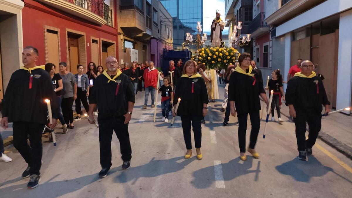 La comisión organizadora, la peña La Clack, desfila delante de la imagen de Sant Antoni en la procesión en su honor.