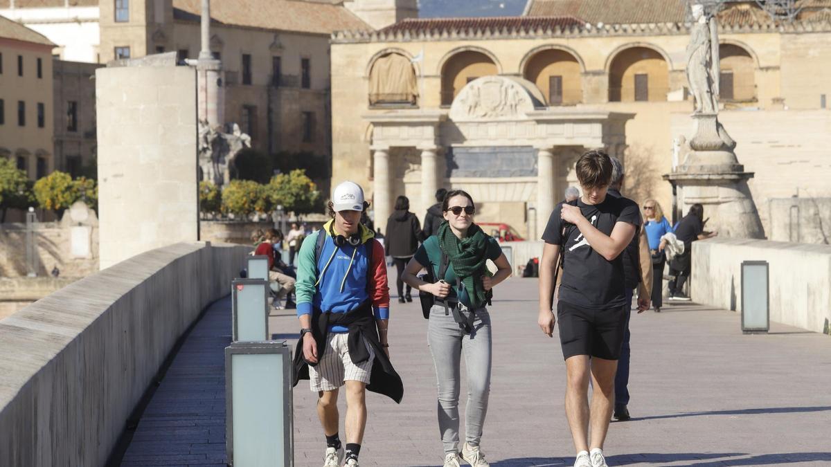Turistas pasean por el Puente Romano de Córdoba.