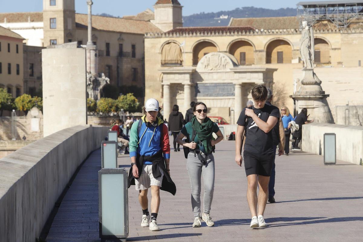 Turistas pasean por el Puente Romano de Córdoba.