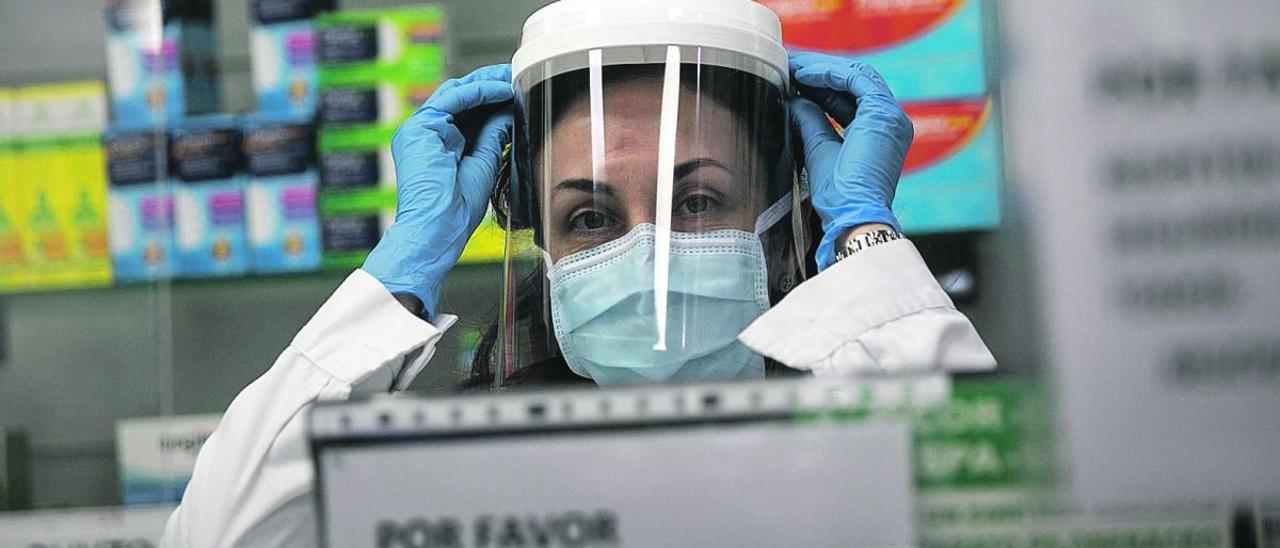 La farmacéutica Patricia Bartolomé se pone una máscara de protección