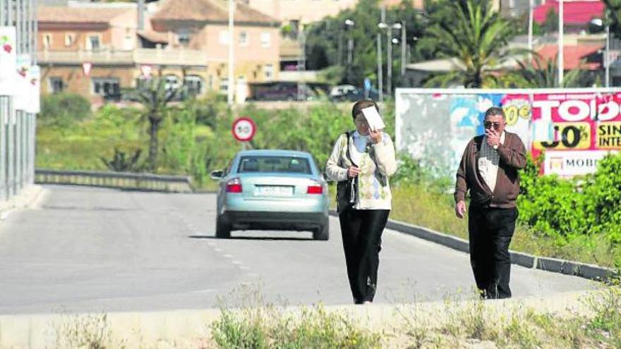 La carretera de Ociopía (al fondo) a la N-340 es la única forma de ir a pie al Cementerio desde el centro.