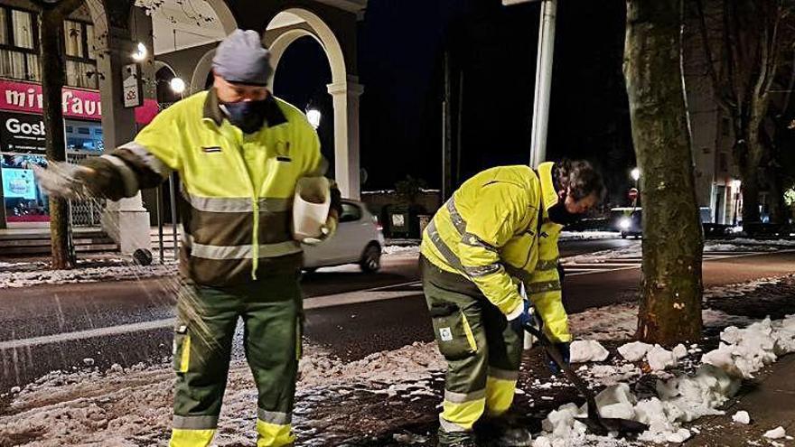 Treballadors de la brigada llançant sal als carrers d&#039;Olot.