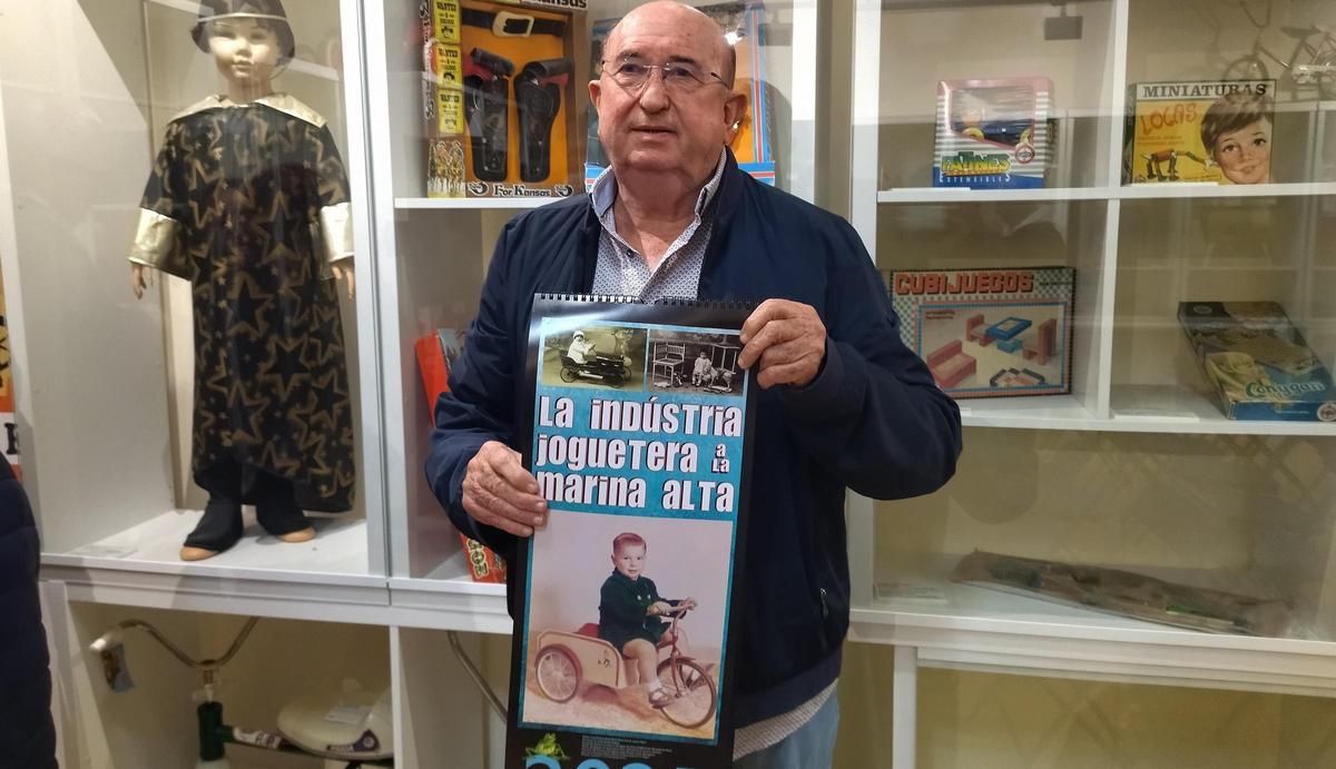 Manolo Noguera, quien estuvo al frente de la fábrica de juguetes Josman, sostiene el calendario en cuya portada está la foto de su primo en un triciclo