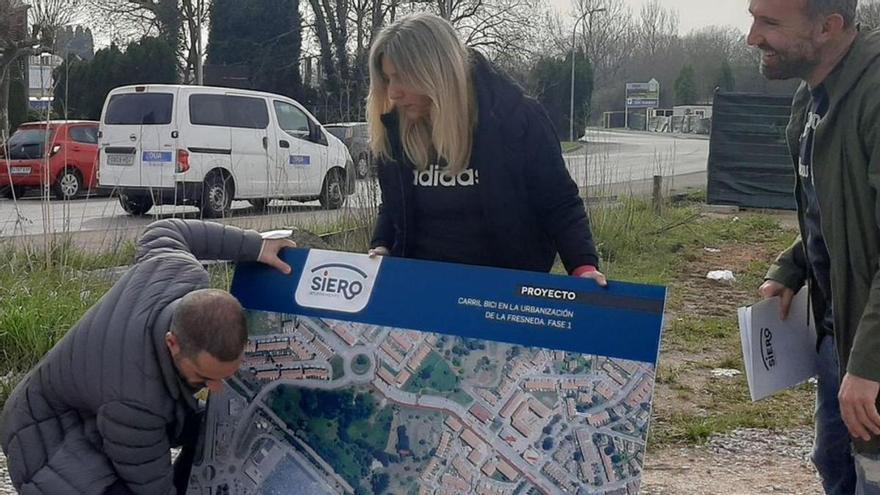 Ángel García, agachado, con los ediles Alejandra Cuadriello y Alberto Pajares, en la presentación del carril bici de La Fresneda. | L. Palacios