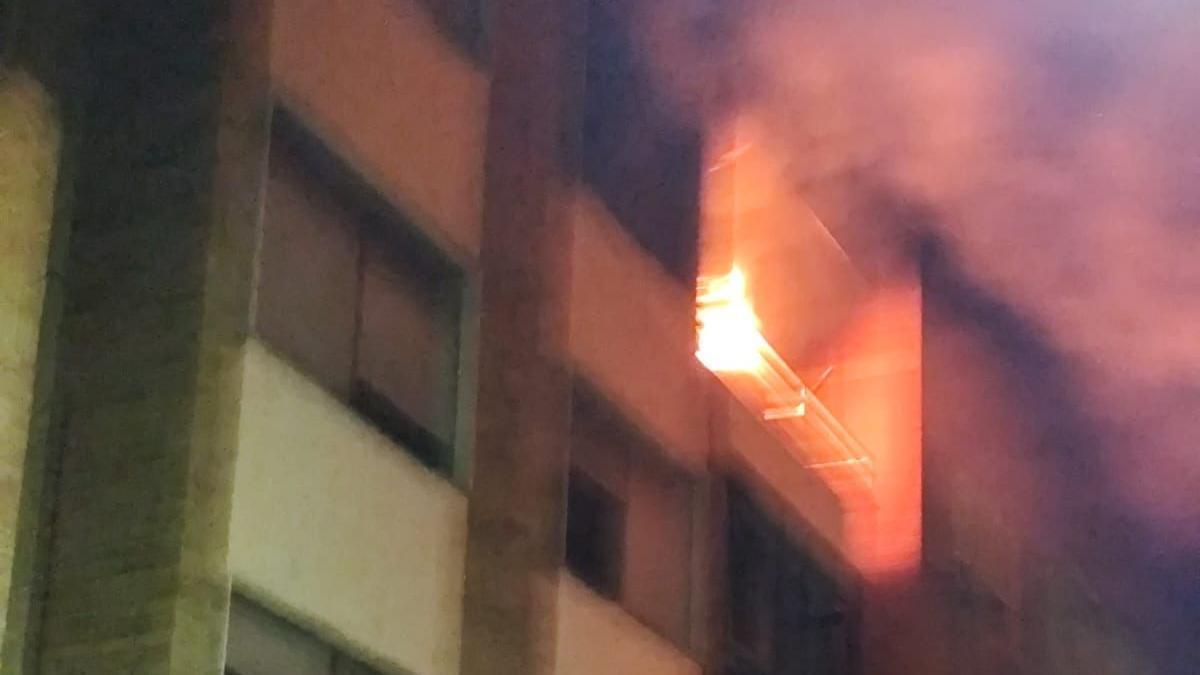 Las llamas asoman por el balcón de la vivienda afectada por el incendio del miércoles.