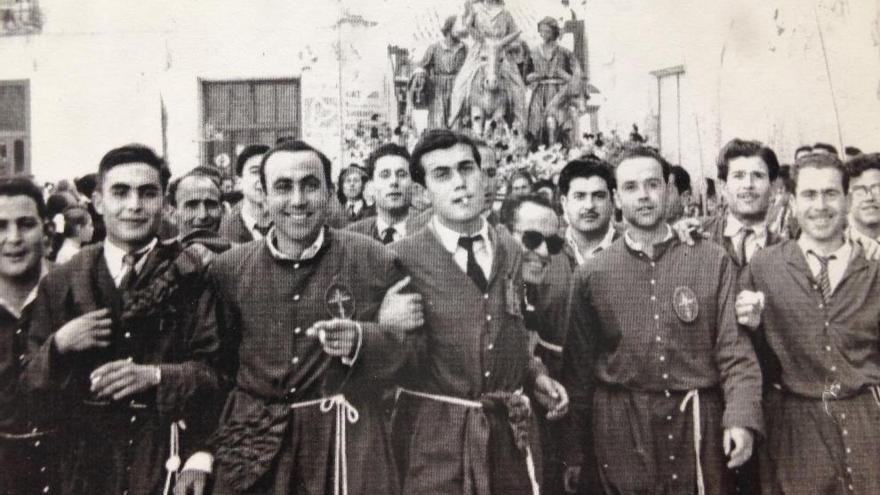 Jóvenes cofrades, en un Domingo de Ramos, con ´La Burrica´ al fondo