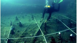 Un arqueólogo recupera una canoa prehistórica hallada a las orillas del poblado neolítico de La Marmotta.