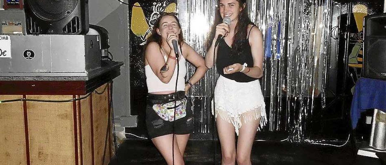 Dos jóvenes cantando en el karaoke.