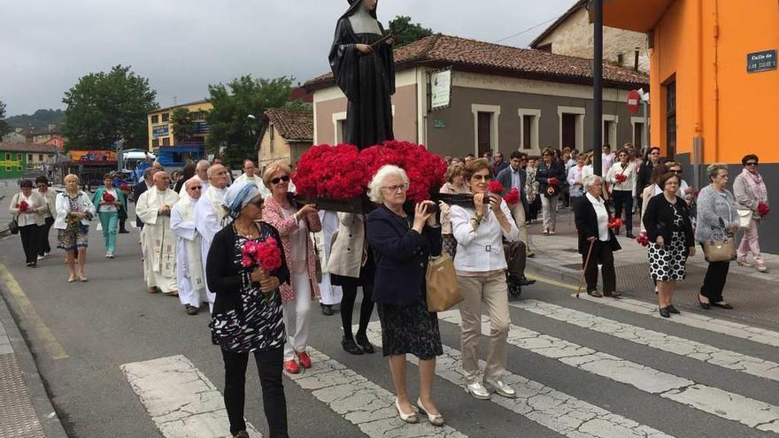 A la izquierda, la imagen de Santa Rita en procesión por las calles de Arriondas. Sobre estas líneas, el ramu de la asociación de comerciantes. A la derecha, Julia Pintueles, Lula Sánchez y Tere de Diego, con sus rosas, en la iglesia.