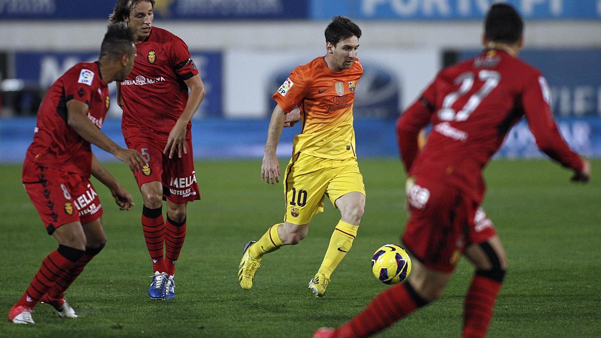 Messi conduce el balón ante Pina y Nsue en el partido disputado el 11 de noviembre de 2012 en Son Moix.