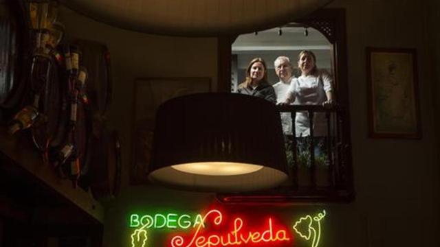 Desde el balcón y sobre el emblemático rótulo luminoso, Núria, Josep y Sònia Solà.