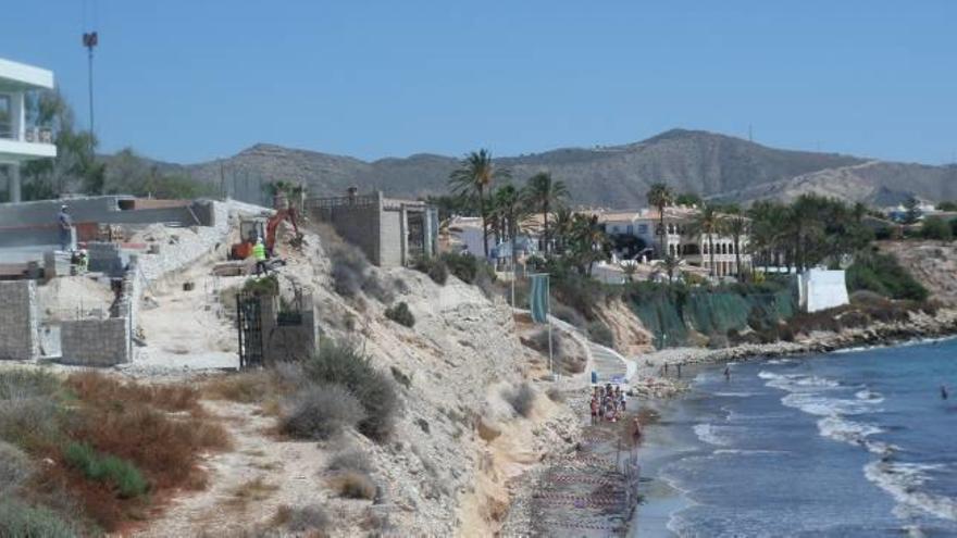 Imagen de ayer a mediodía de las obras en la parte superior del acantilado, con una parte de la playa vallada.