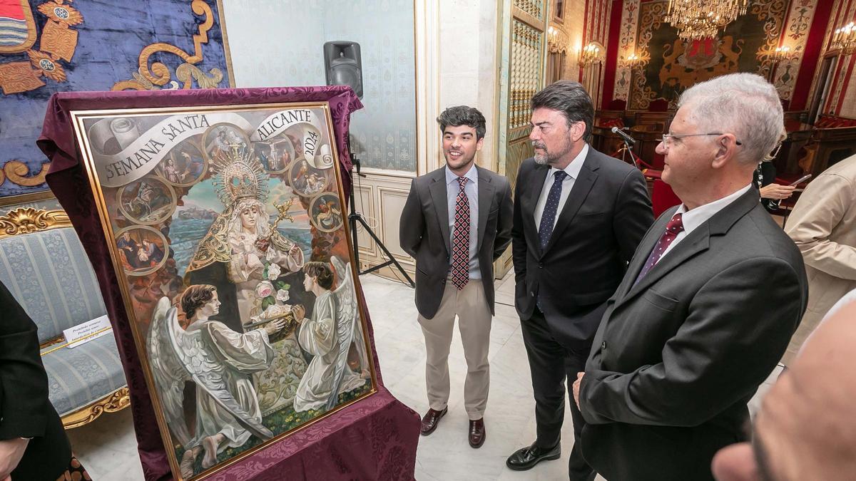 El artista  Pedro Castro, el alcalde Luis Barcala y el concejal Julio Calero, junto al cartel de Semana Santa.