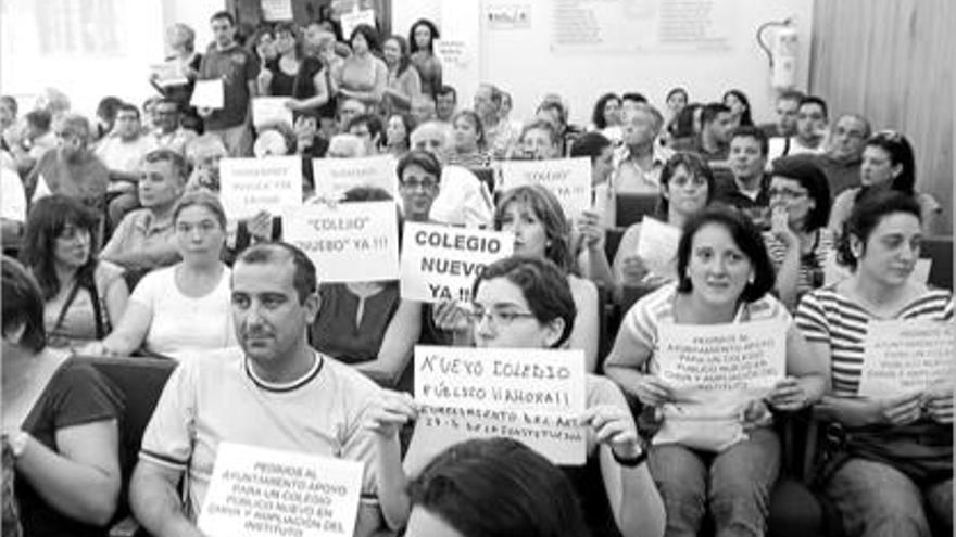 Miembros de las AMPA sacando los carteles de protesta en la sesión plenaria de Chiva.