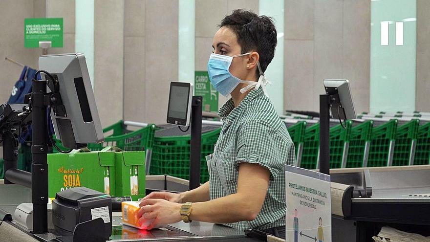 Cajera de Mercadona, en un supermercado de la cadena de València, protegida por una mampara.