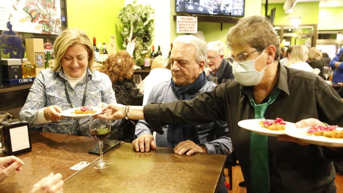 Geli Zarracina, sirviendo su pincho a Ana María Ruiz y a Ander Ormaechea, ayer, en su local de la calle Begoña. | Ángel González