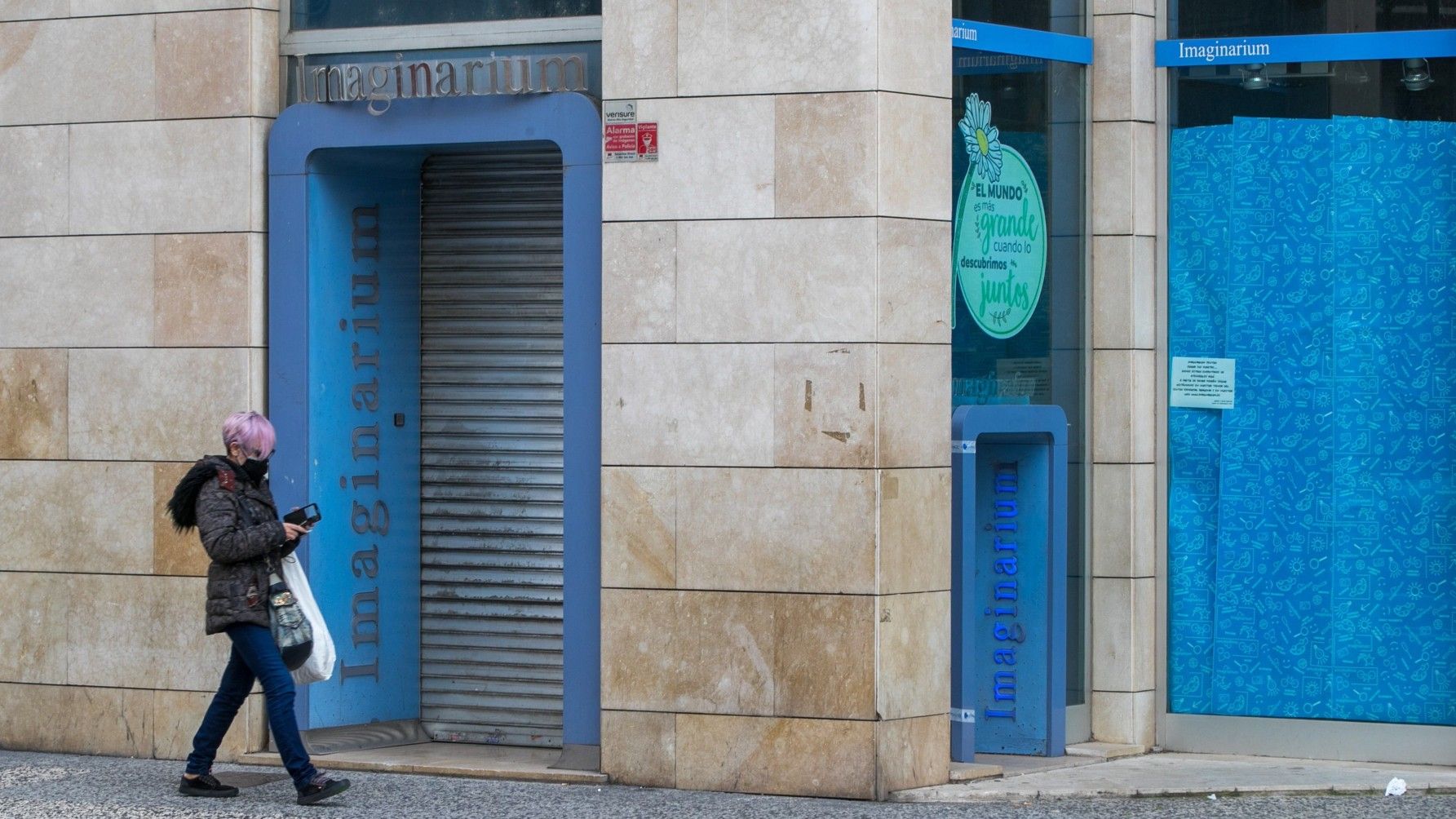 Una mujer camina junto a una de las tiendas cerradas de Imaginarium en Zaragoza, el pasado día 18.