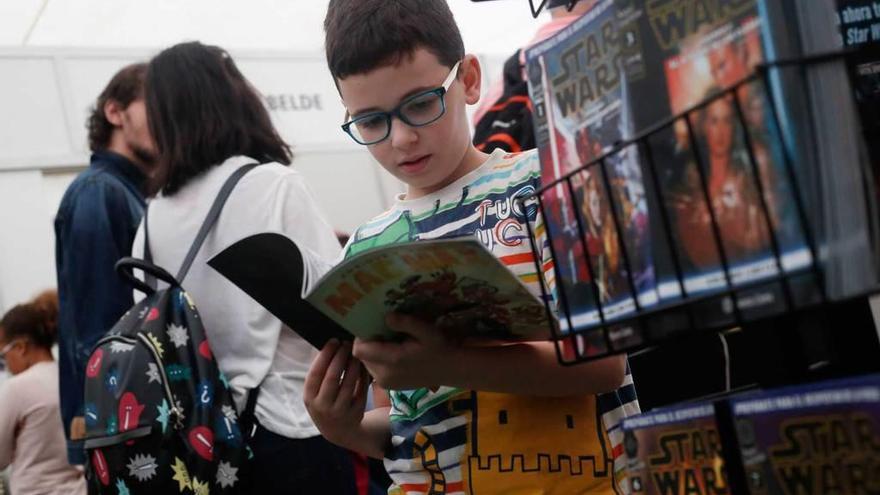 Un niño hojea un comic en la pasada edición de las jornadas avilesinas.