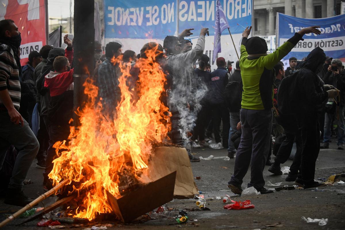 Manifestantes chocan con la policía antidisturbios frente al Congreso Nacional en Buenos Aires el 12 de junio de 2024. Los senadores argentinos debaten un paquete de reformas clave para el presidente ultraderechista Javier Milei, en una sesión marcada por huelgas y manifestaciones frente al Congreso.