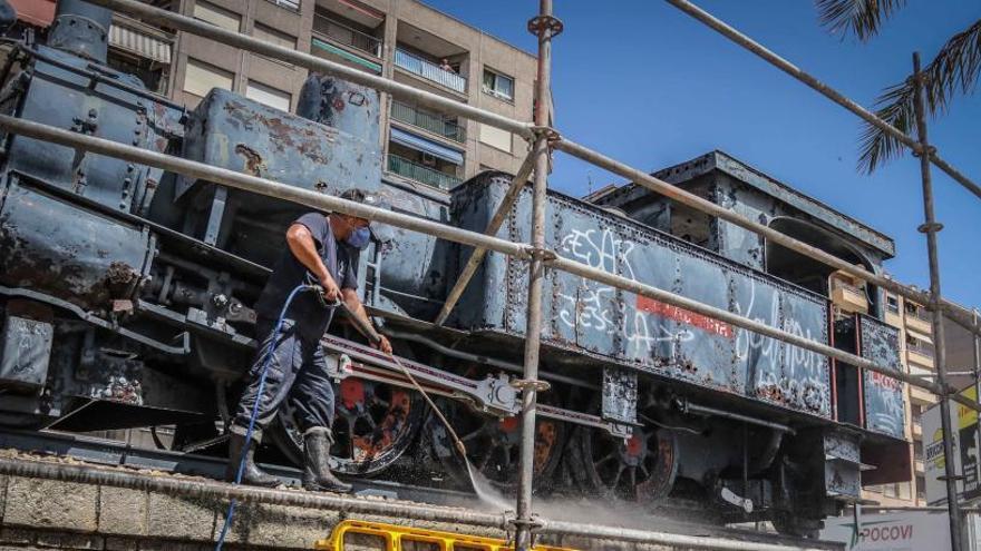 Un operario limpiando la locomotora situada en la plaza Al-Azraq