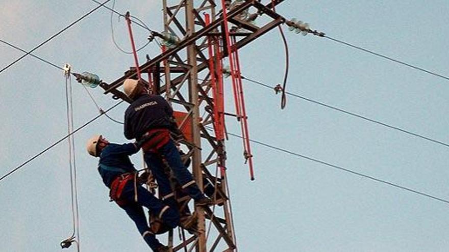 Dos operarios, en una torre de tendido eléctrico.