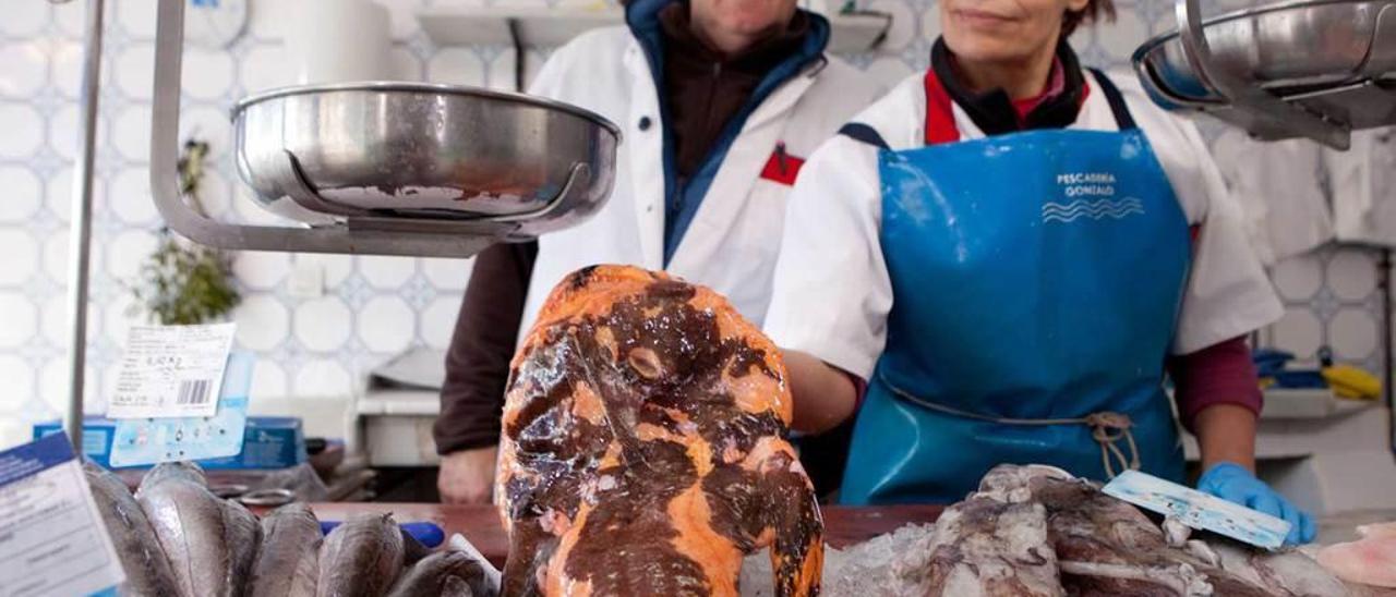 Candelaria de León y Gonzalo García, en su pescadería, con una rareza de pixín.