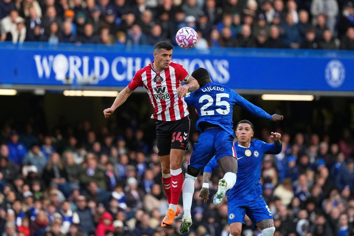 Sunderland's Granit Xhaka, left, jumps for the ball with Chelsea's Moises Caicedo while Chelsea's Enzo Fernandez looks on during the English Premier League soccer match between Chelsea and Sunderland in London, Saturday, Oct. 25, 2025. (AP Photo/Joanna Chan)
