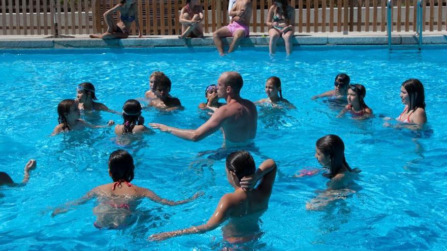 Menores en una piscina en verano.