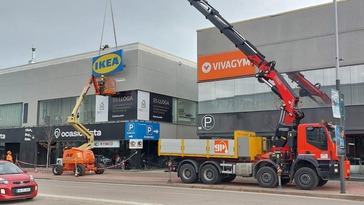 Grues col·locant el cartell de la multinacional de mobles.