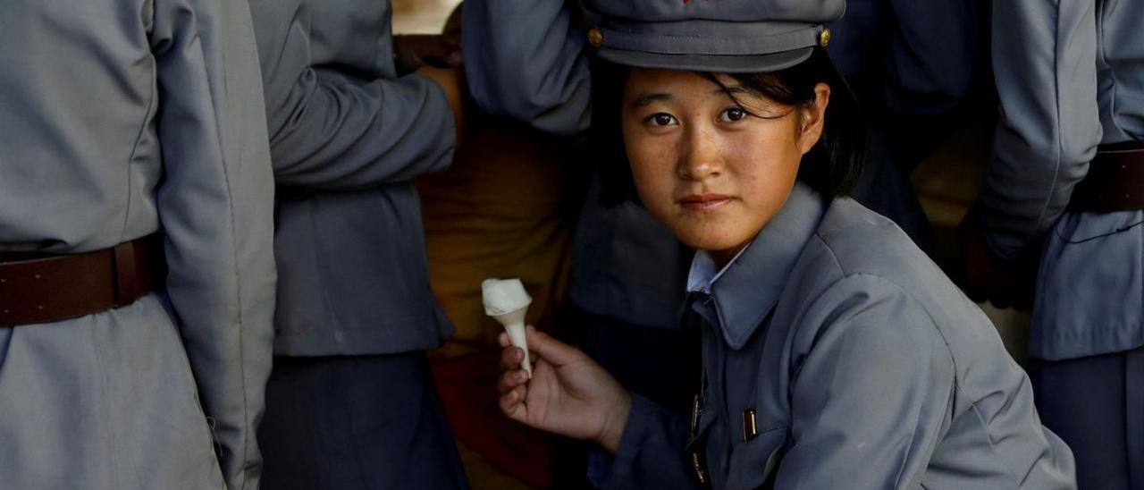 Una joven soldado norcoreana se come un helado durante una visita en el zoo de Pyongyang, en una imagen de 2018.