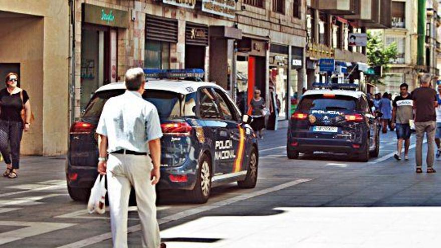 Dos coches de la Policía Nacional patrullan en las calles peatonales.