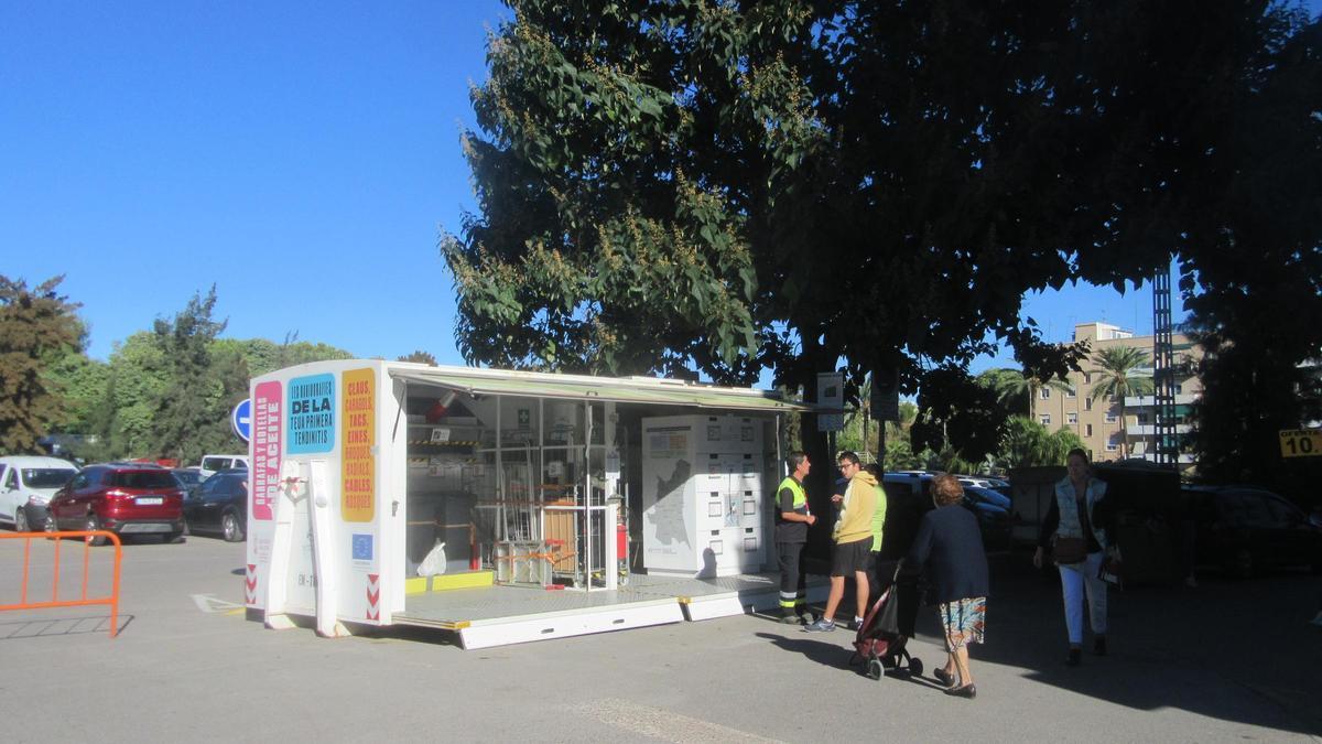 Un operario de la Emtre atiende a un grupo de usuarios del ecoparque móvil en Burjassot.