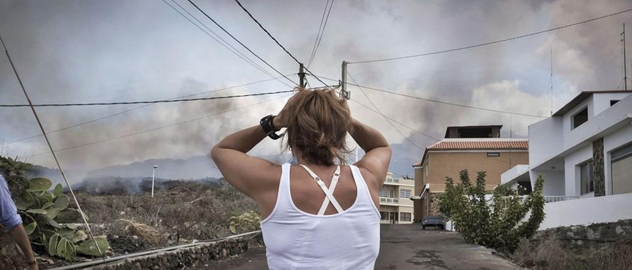 Vecinos desalojados observan su casa a punto de ser engullida.