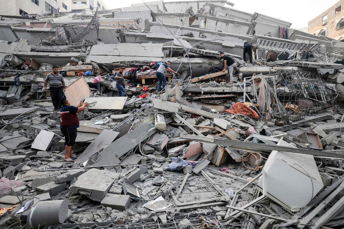 Residentes de la ciudad de Gaza tratan de recuperar sus enseres de un edificio destruido durante un ataque aéreo de Israel.