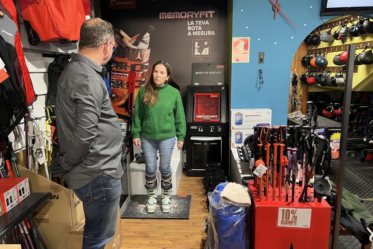 Una persona emprovant-se unes botes d'esquí en una botiga de venda i lloguer de material a Sort