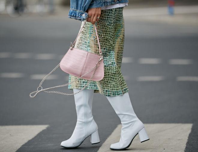 Botas blanca con falda midi en el street style de Estocolmo