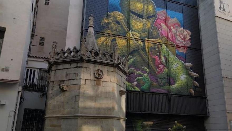 La Font Gòtica, a l’esquerra, i el mural de Saturno pintat a la façana del Teatre de Blanes.