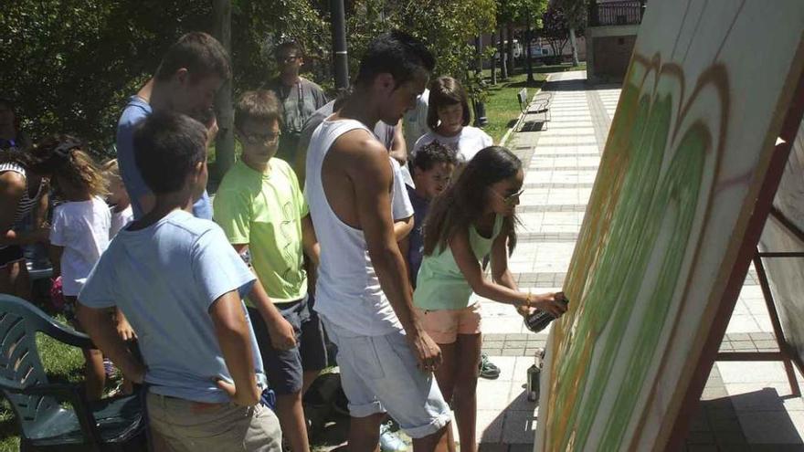 Uno de los monitores supervisa el trabajo realizado por una de las niñas participantes en el taller. Foto